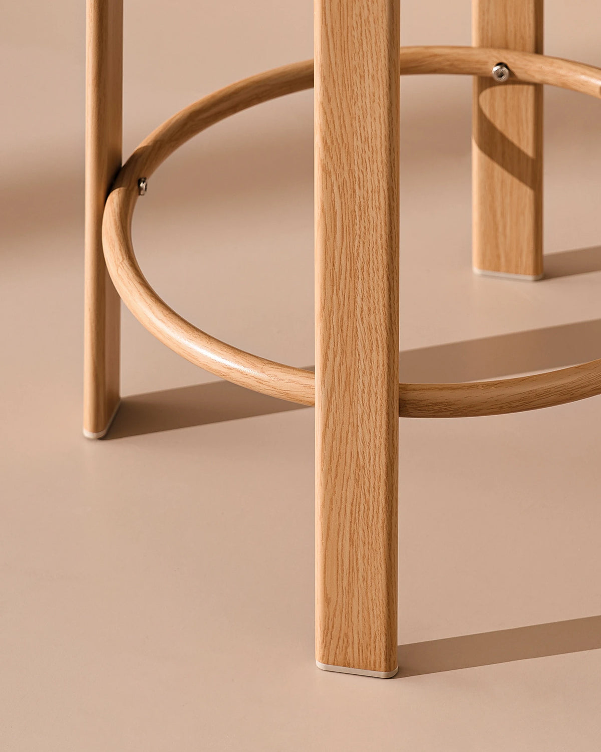 Detail of the integrated footrest on the oak-effect metal frame of the Bramley bar stool