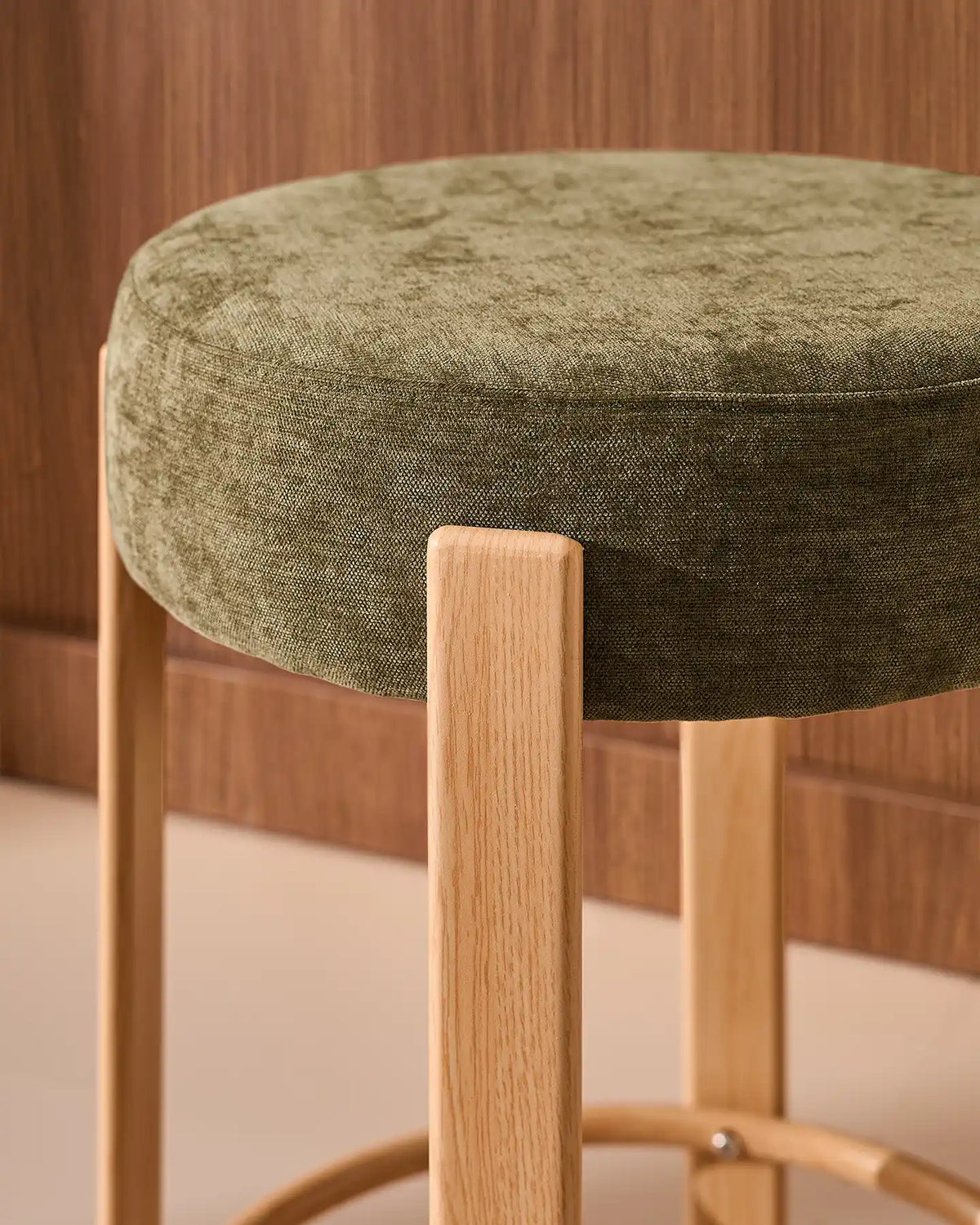Close-up of the round seat with soft olive green chenille upholstery