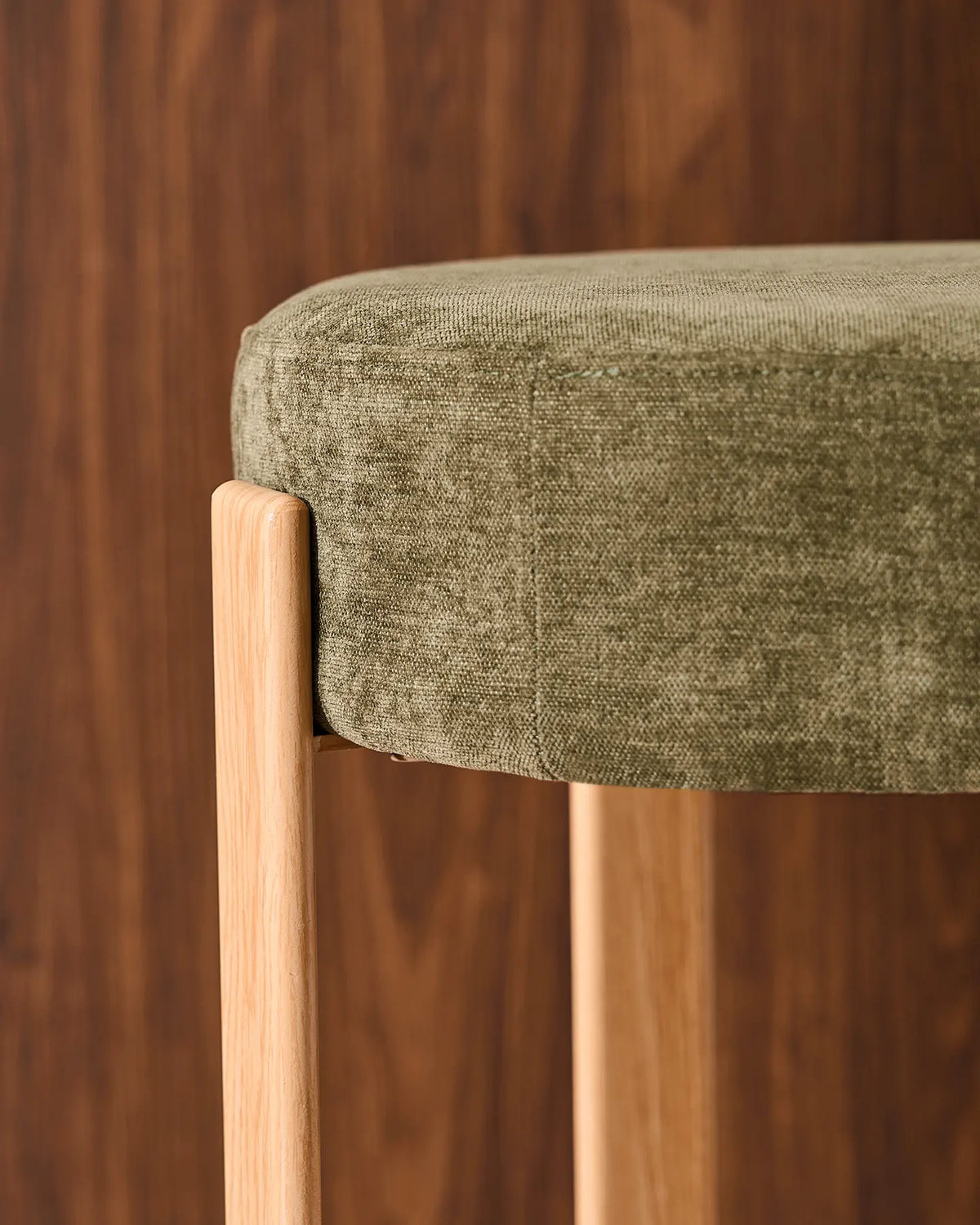 Close-up of the round seat with soft olive green chenille upholstery