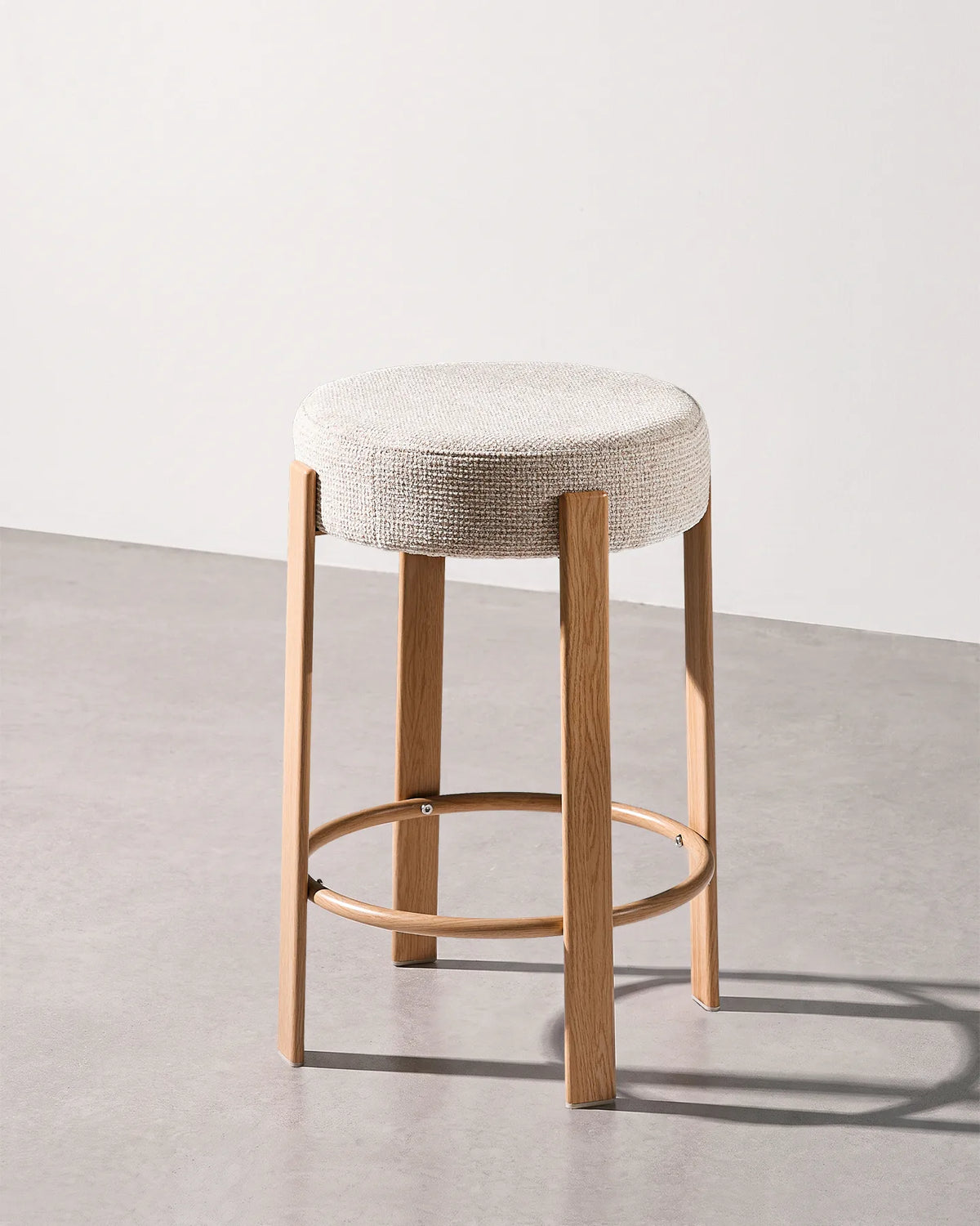 Bramley beige chenille bar stool with a round upholstered seat and integrated footrest