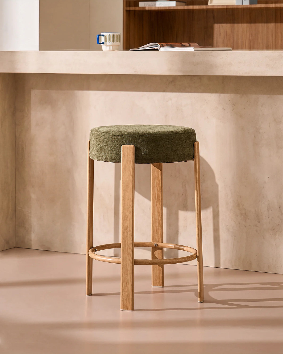 Side view of the Bramley olive green chenille bar stool with 65 cm seat height and oak-effect metal frame