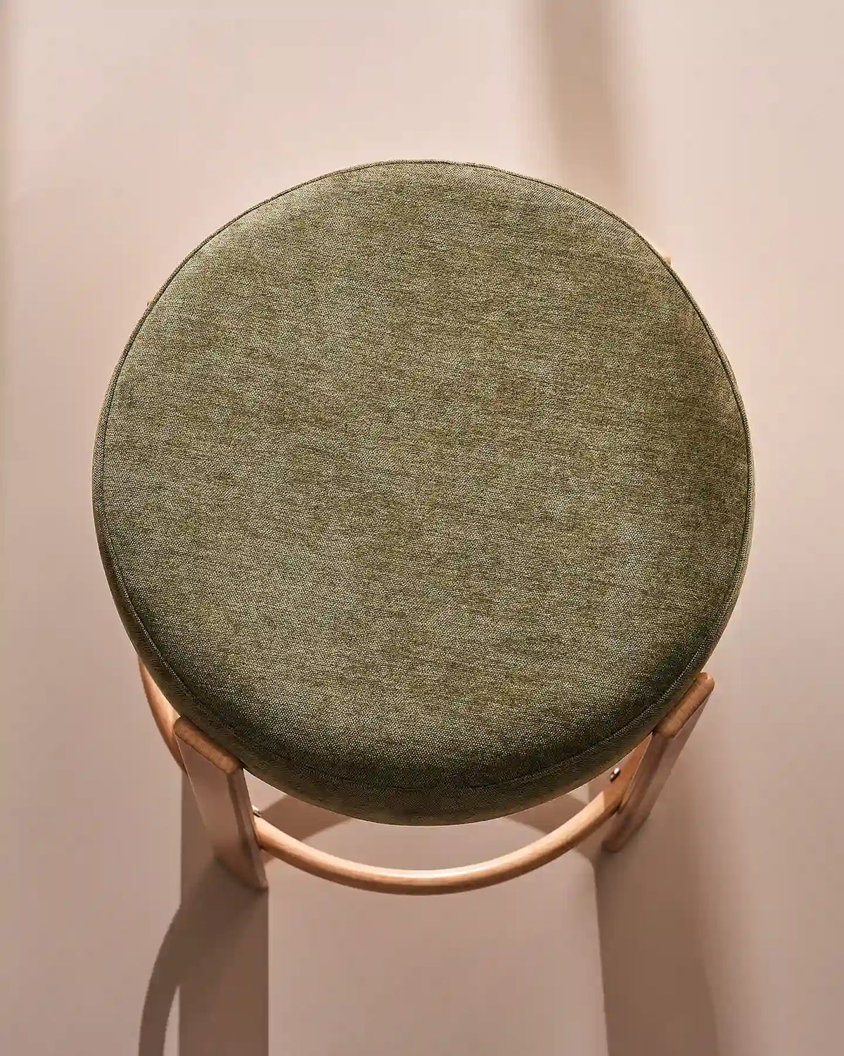 Close-up of the round seat with soft olive green chenille upholstery
