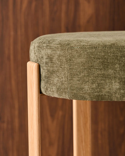 Close-up of the round seat with soft olive green chenille upholstery