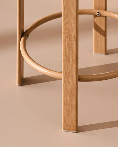 Detail of the integrated footrest on the oak-effect metal frame of the Bramley bar stool