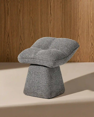 Tabouret pivotant en chenille gris Liora montrant son siège incurvé et sa base effilée.